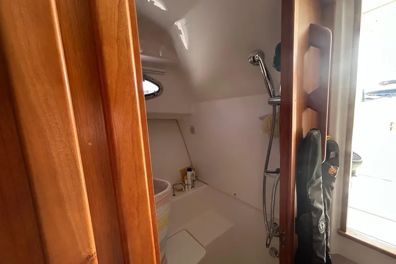 Fifth Child Yacht Photos Pics 2019 Back Cove 34O boat interior shower with wooden door and porthole window.