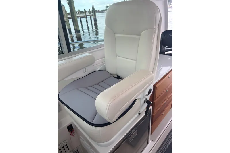 Fifth Child Yacht Photos Pics Captain's chair on 2019 Back Cove 34O boat, featuring white upholstery and armrests.