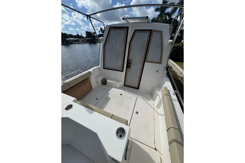  Yacht Photos Pics 2021 Ranger Tugs R-25 boat deck with seating, docked by a scenic waterfront.