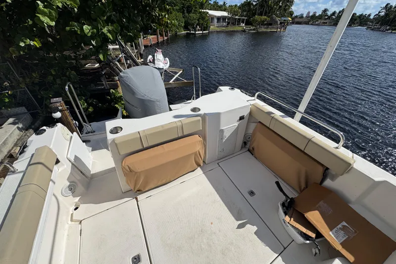  Yacht Photos Pics 2021 Ranger Tugs R-25 boat deck with seating, overlooking a serene waterfront.