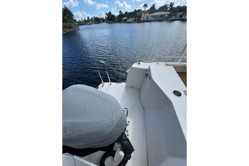  Yacht Photos Pics 2021 Ranger Tugs R-25 boat on a serene waterfront with clear skies.