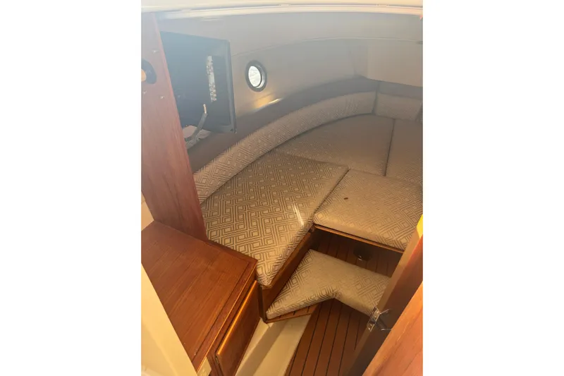  Yacht Photos Pics 2021 Ranger Tugs R-25 cabin interior with cushioned seating and wooden accents.
