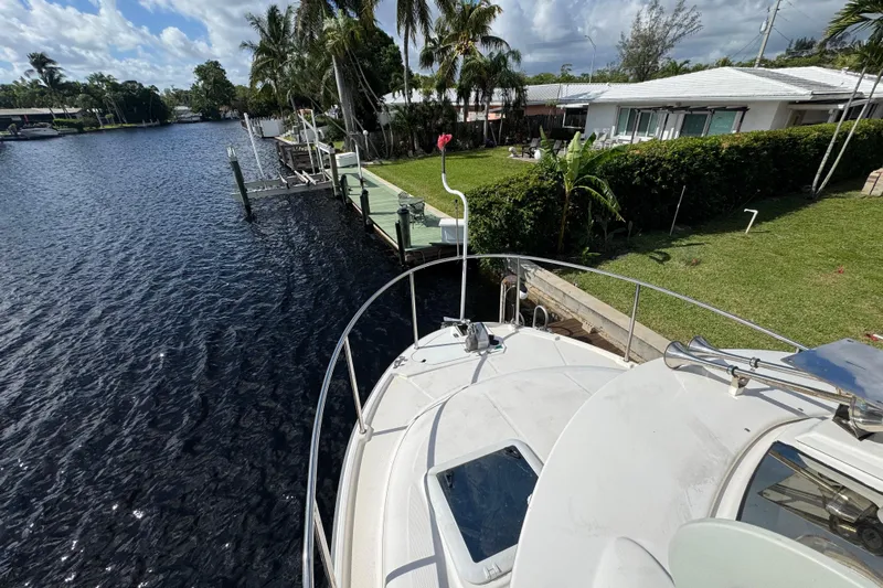  Yacht Photos Pics 2021 Ranger Tugs R-25 docked by a lush, tropical waterfront home.