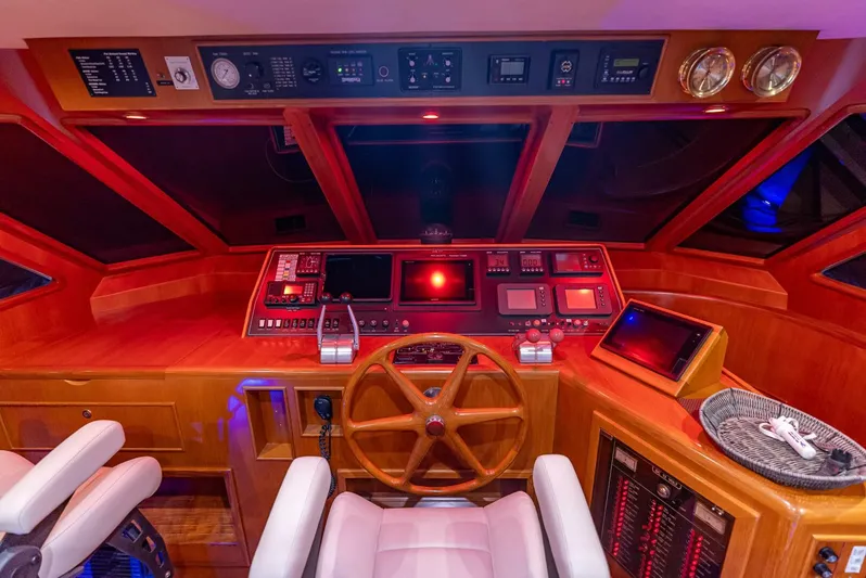 Mountain Mermaid Yacht Photos Pics Pilothouse interior of 2004 Offshore Yachts 54, featuring navigation controls and wooden steering wheel.