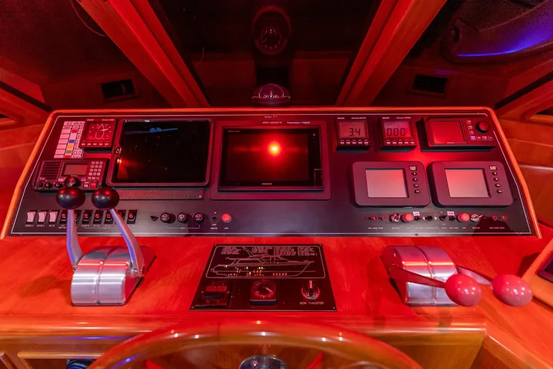 Mountain Mermaid Yacht Photos Pics Control panel of a 2004 Offshore Yachts 54 Pilothouse, illuminated in red lighting.