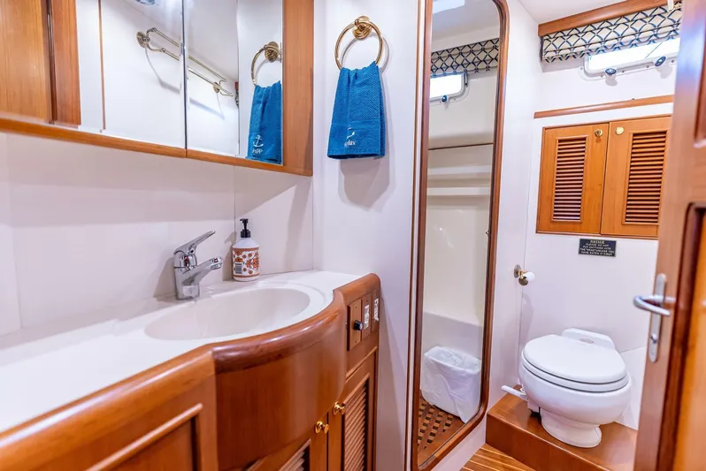 Mountain Mermaid Yacht Photos Pics Luxurious bathroom in 2004 Offshore Yachts 54 Pilothouse, featuring wood cabinetry and modern fixtures.