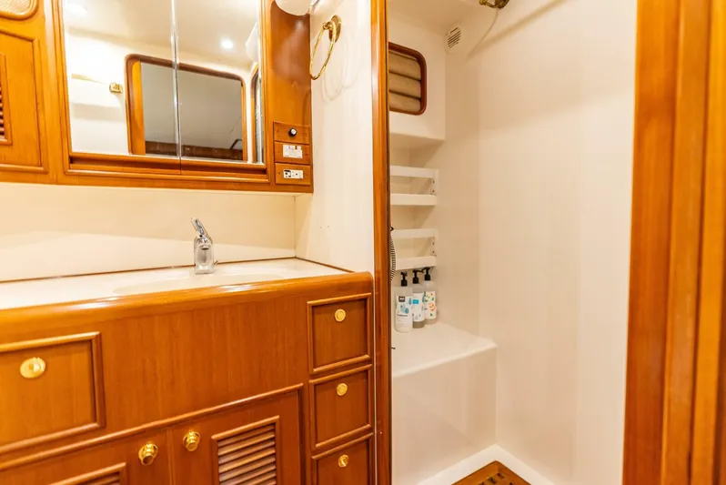 Mountain Mermaid Yacht Photos Pics Luxurious bathroom in 2004 Offshore Yachts 54 Pilothouse with wooden cabinetry and modern fixtures.