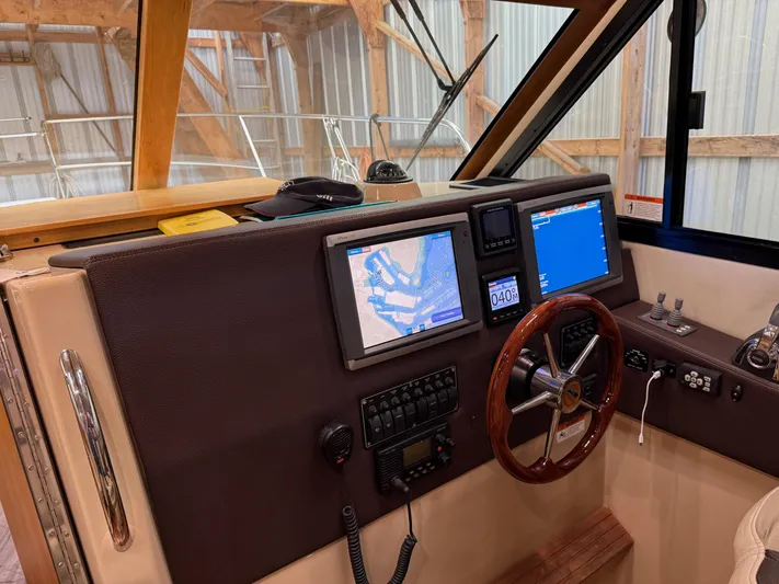 Cannery Row Yacht Photos Pics 2015 Cutwater C-30 Sedan helm with navigation screens and wooden steering wheel.