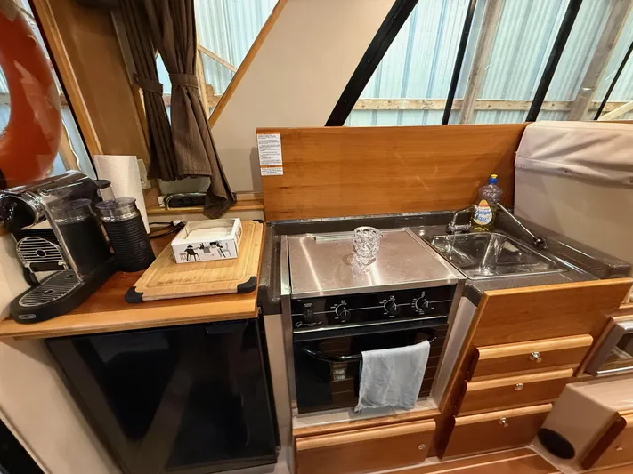 Cannery Row Yacht Photos Pics Compact kitchen in 2015 Cutwater C-30 Sedan with stove, sink, and coffee maker.