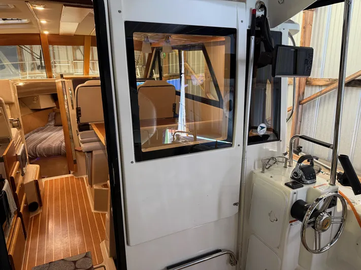 Cannery Row Yacht Photos Pics 2015 Cutwater C-30 Sedan interior with helm, seating, and wood flooring.
