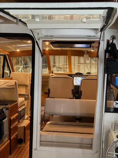 Cannery Row Yacht Photos Pics Interior view of 2015 Cutwater C-30 Sedan boat with beige seating and wooden accents.