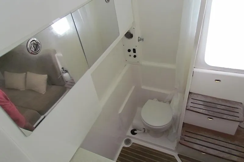  Yacht Photos Pics Interior of 2016 Everglades 435 Center Console boat, featuring a compact bathroom with toilet and mirror.