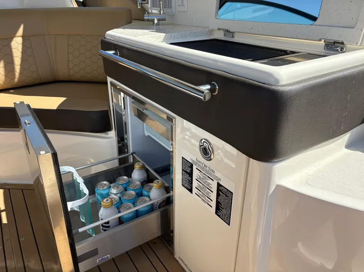  Yacht Photos Pics Outdoor kitchenette on 2020 Sea Ray 320 Sundancer with open fridge and drinks.