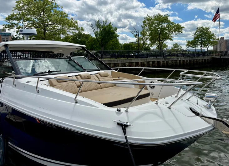  Yacht Photos Pics 2020 Sea Ray 320 Sundancer boat docked by a waterfront with trees and cloudy sky.