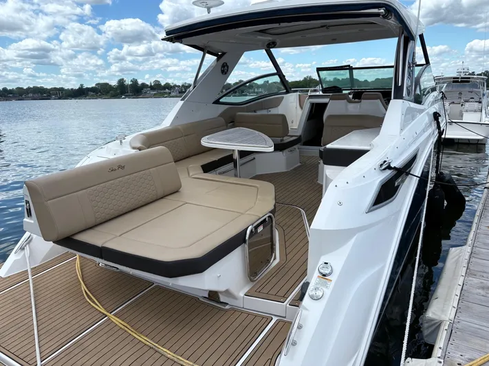  Yacht Photos Pics 2020 Sea Ray 320 Sundancer yacht with spacious seating, docked by a serene lake.
