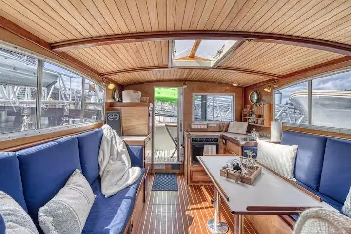 Interior of 1996 Devlin 38 boat with wooden finish and blue seating.