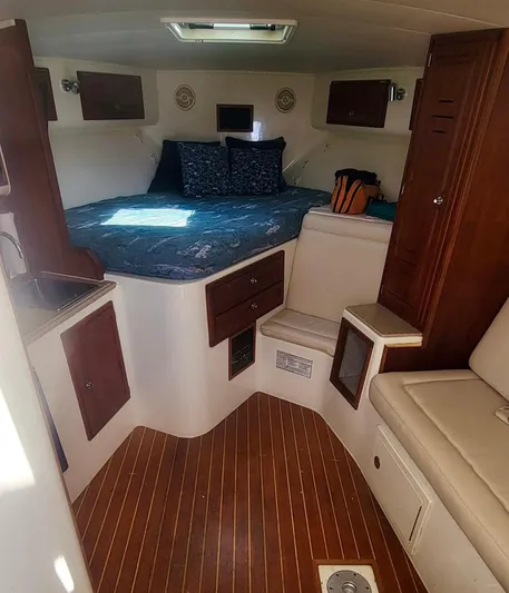 Robin Ann Yacht Photos Pics 2004 Carolina Classic 35 Express cabin with bed, seating, and wood accents.