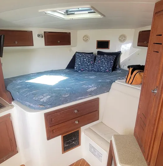 Robin Ann Yacht Photos Pics 2004 Carolina Classic 35 Express cabin with bed, wooden cabinets, and natural light.