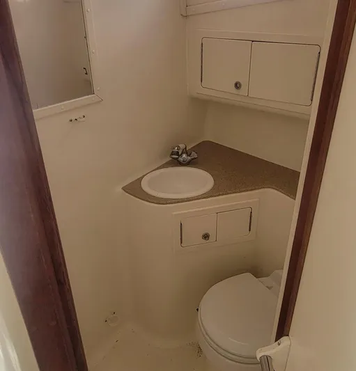 Robin Ann Yacht Photos Pics 2004 Carolina Classic 35 Express boat bathroom with sink, toilet, and storage cabinets.
