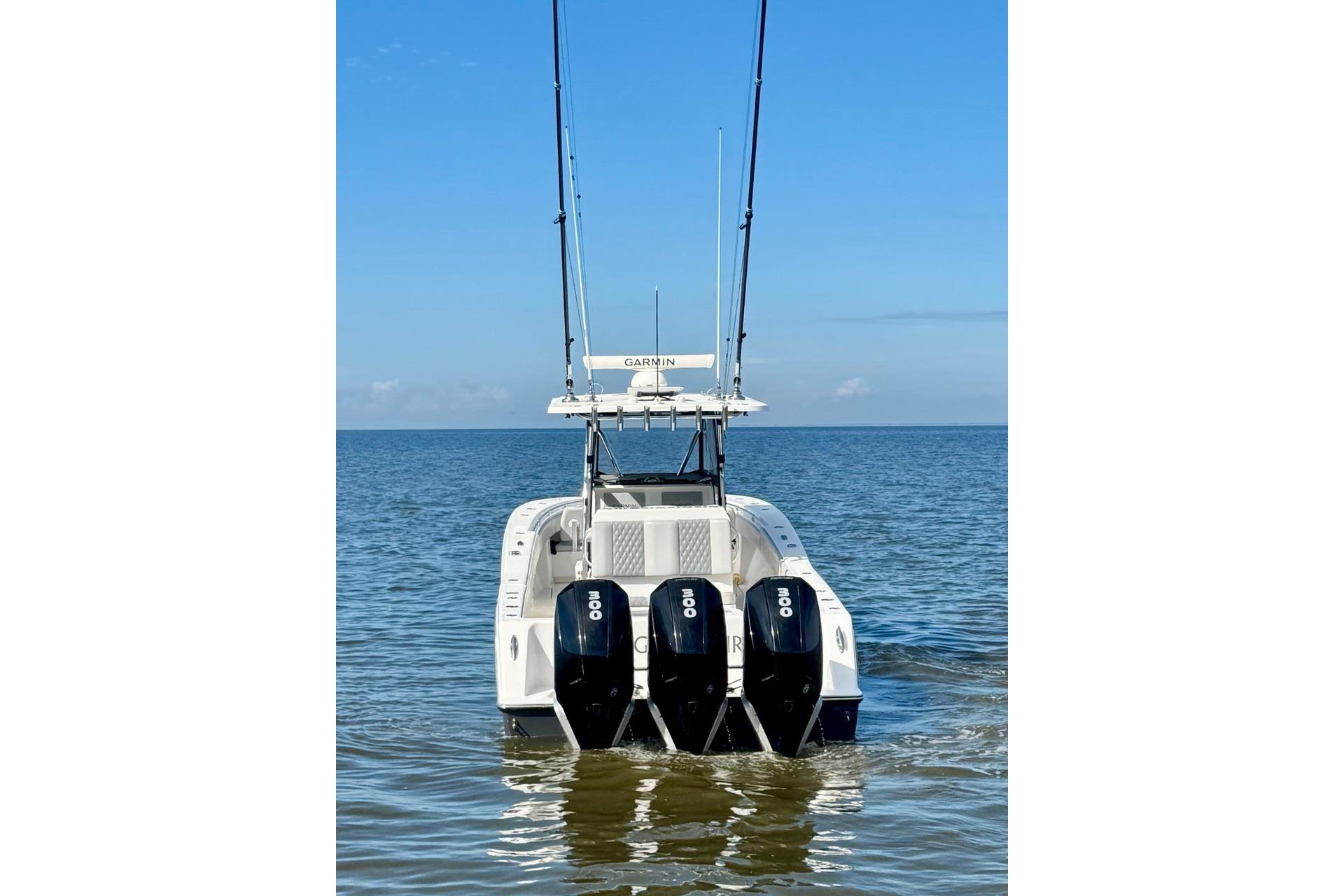 2020 Invincible 36 Open Fisherman boat with triple engines on calm water.