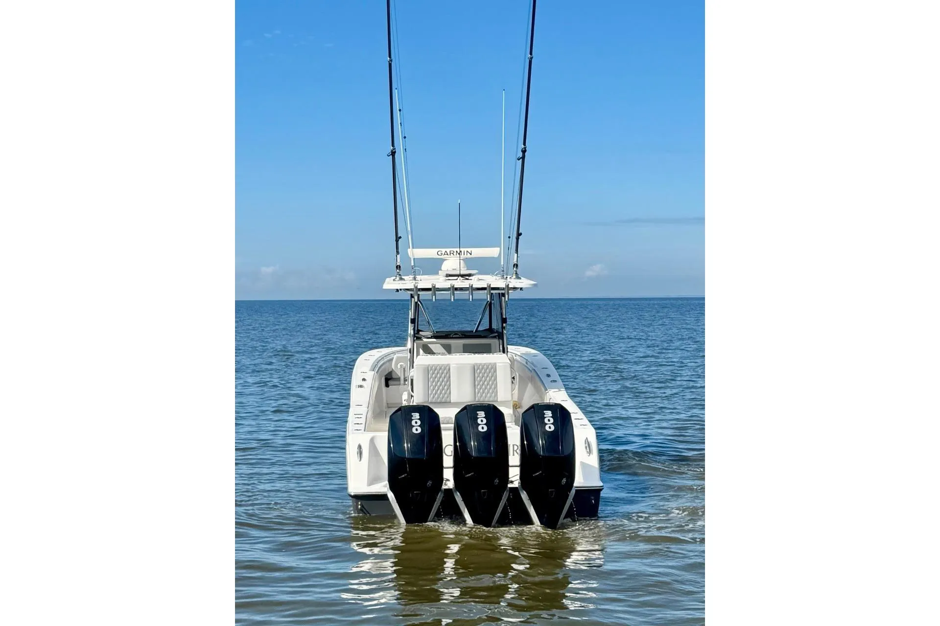 2020 Invincible 36 Open Fisherman boat with triple engines on calm water.