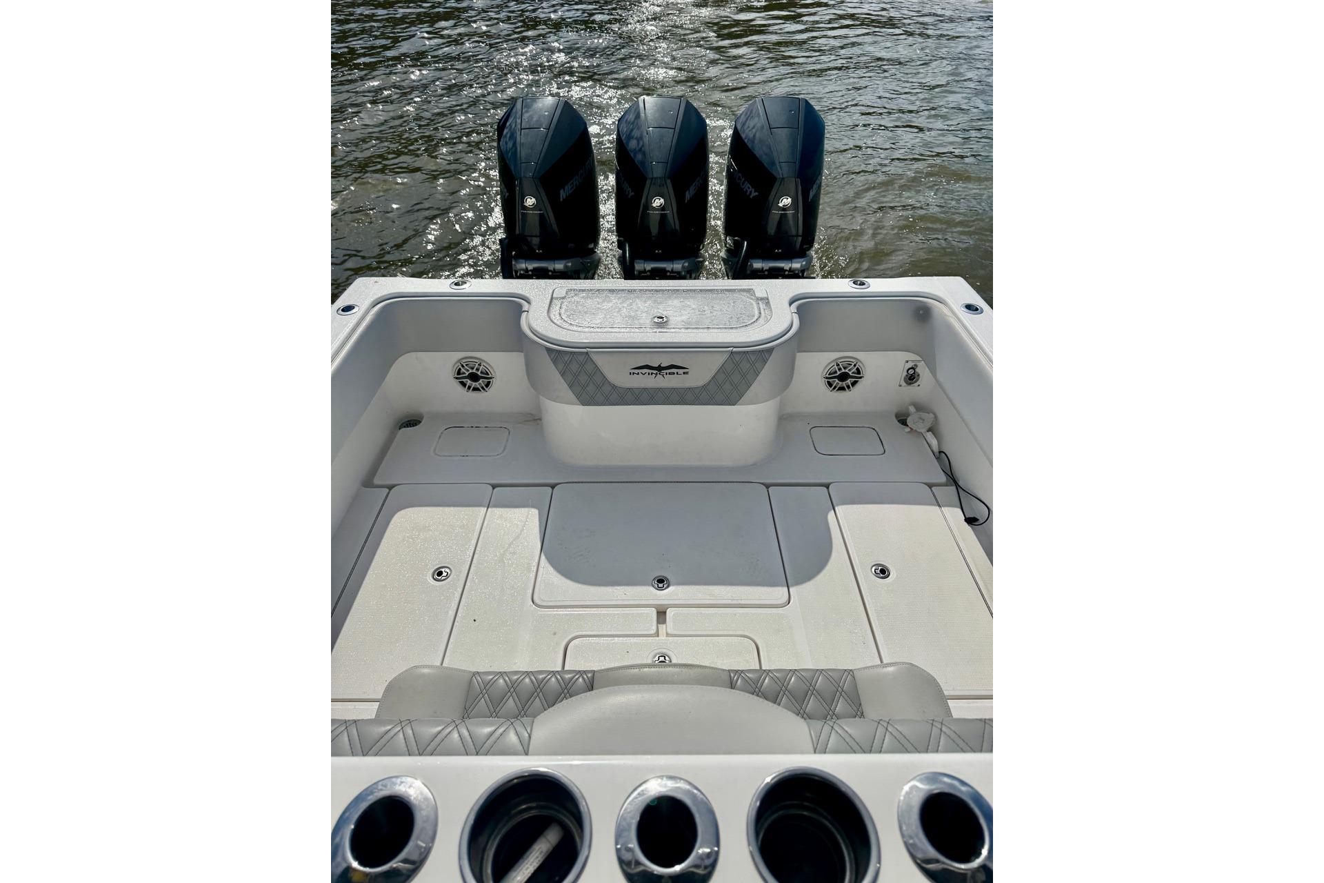 2020 Invincible 36 Open Fisherman boat with triple outboard motors on water.