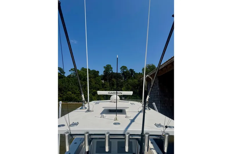  Yacht Photos Pics 2020 Invincible 36 Open Fisherman boat with Garmin equipment, docked near lush greenery.