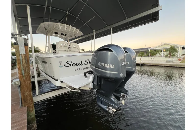  Yacht Photos Pics 2018 Regulator 28 boat with twin Yamaha 300 engines docked under a canopy.