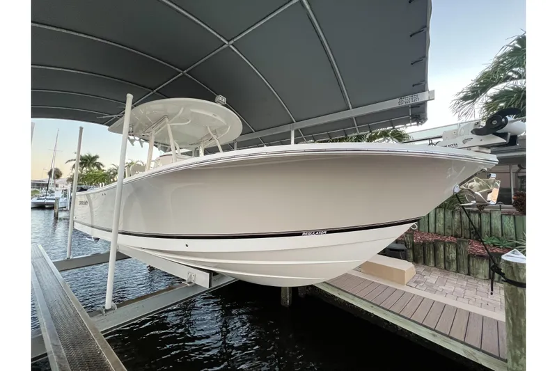  Yacht Photos Pics 2018 Regulator 28 boat on lift under canopy, docked near water.