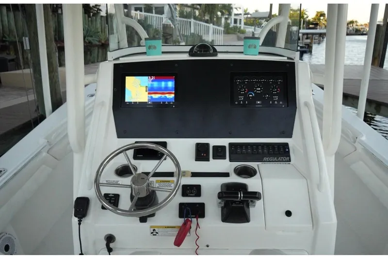  Yacht Photos Pics 2018 Regulator 28 boat dashboard with navigation screens and steering wheel.