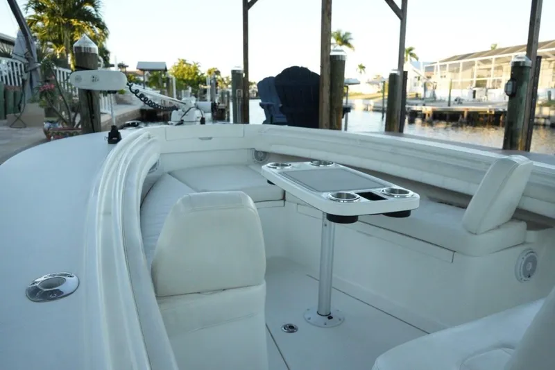  Yacht Photos Pics 2018 Regulator 28 boat interior with seating and table, docked by waterfront homes.