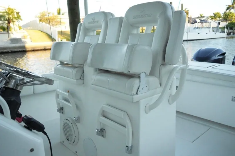  Yacht Photos Pics 2018 Regulator 28 boat interior with dual white captain's chairs and steering wheel.