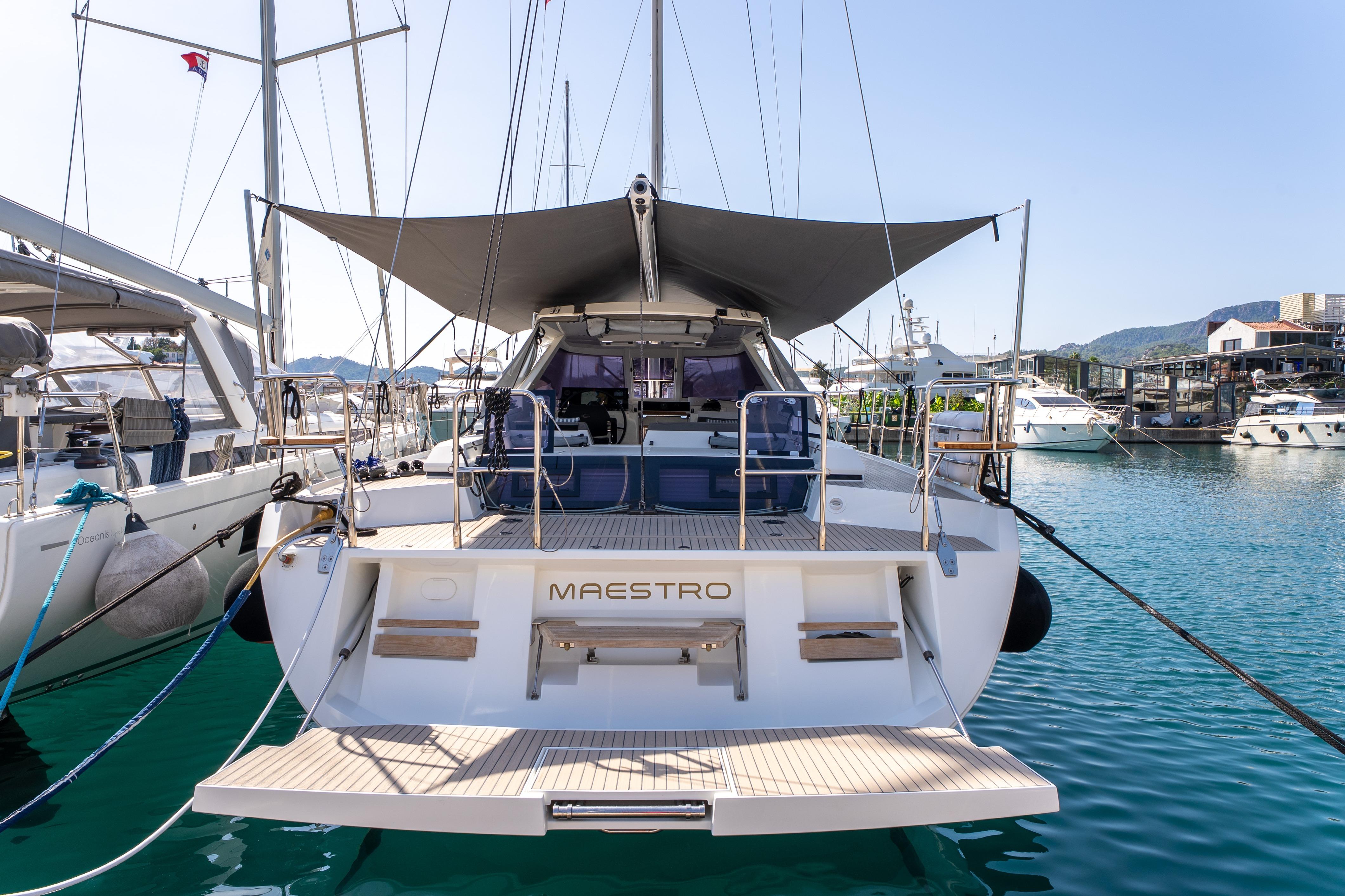 2019 Amel 50 yacht docked in marina, featuring spacious deck and sunshade.