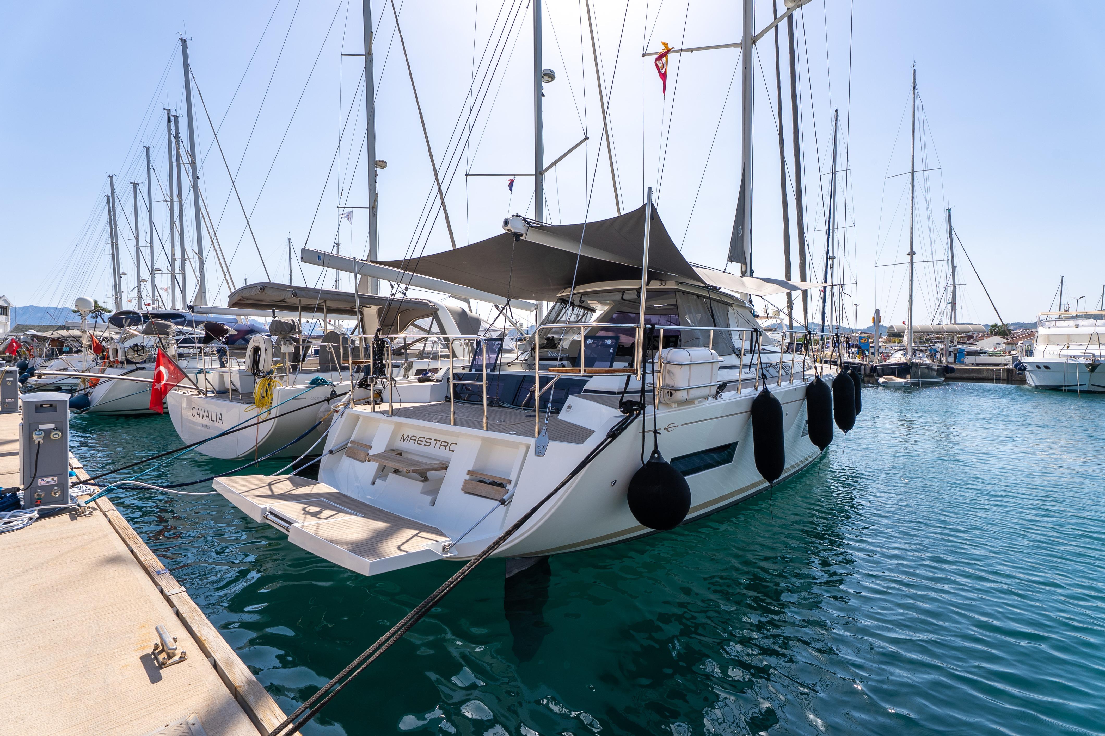 2019 Amel 50 yacht docked in a marina, surrounded by other sailboats.