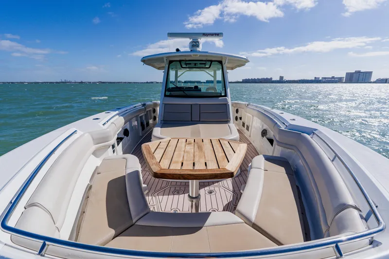 Spec-tacular Li Li Yacht Photos Pics 2019 Boston Whaler 380 Outrage boat on open water, featuring spacious seating and wooden table.