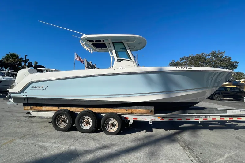  Yacht Photos Pics 2025 Boston Whaler 280 Outrage boat on a trailer under clear blue sky.
