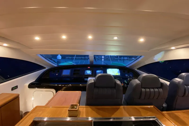 Querencia Yacht Photos Pics Interior cockpit of 2004 Mangusta 72 Hardtop yacht with modern navigation equipment.