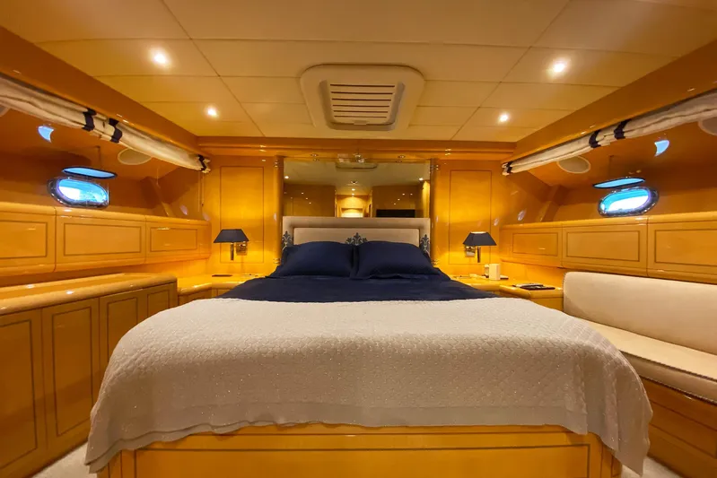 Querencia Yacht Photos Pics Luxurious bedroom interior of 2004 Mangusta 72 Hardtop yacht with elegant wood finishes.