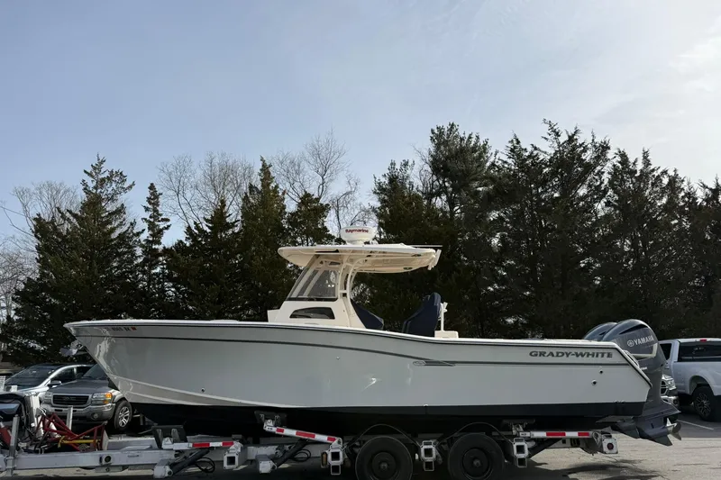  Yacht Photos Pics 2019 Grady-White Canyon 306 boat on trailer, parked outdoors with trees in background.