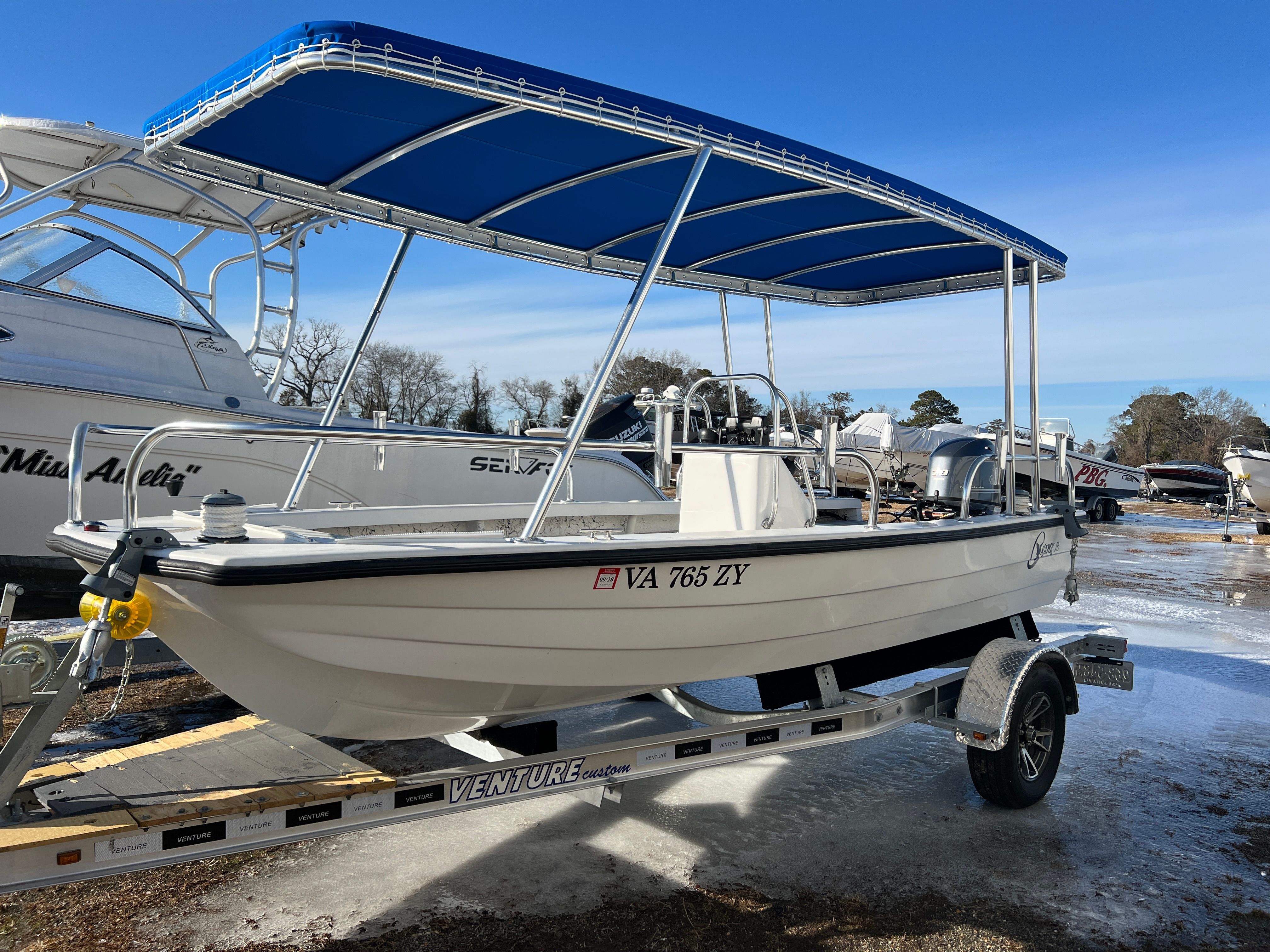 2021 C-Hawk 16 Tiller boat with blue canopy on trailer.