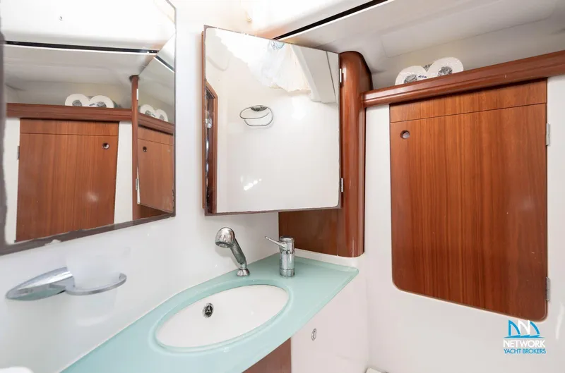  Yacht Photos Pics Bathroom interior of a 2004 Beneteau 57 yacht with wooden cabinetry and modern fixtures.