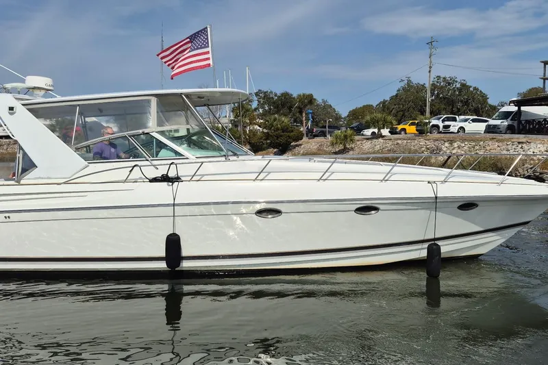 H Yacht Photos Pics 2000 Formula 41 Performance Cruiser with American flag, docked near shoreline.
