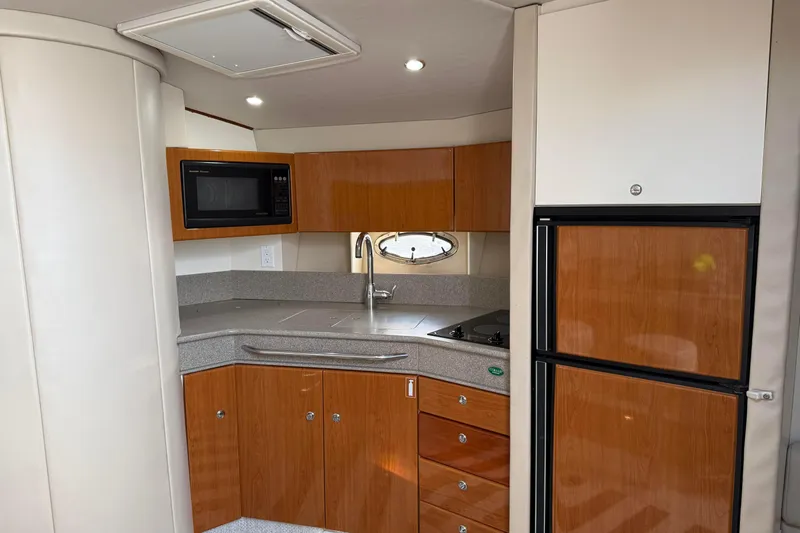 H Yacht Photos Pics Interior of 2000 Formula 41 Performance Cruiser kitchen with wood cabinets and modern appliances.