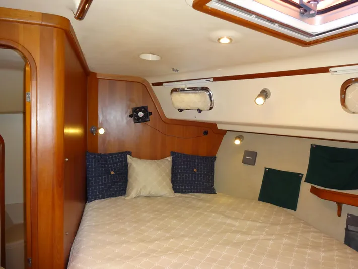 Don't Blink Yacht Photos Pics Cozy cabin interior of 2006 Island Packet 440 sailboat with wood paneling and comfortable bedding.