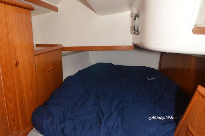 Misty Blue Yonder Yacht Photos Pics Cozy cabin interior of 1995 Jeanneau Sun Odyssey 45.1 sailboat with blue bedding.