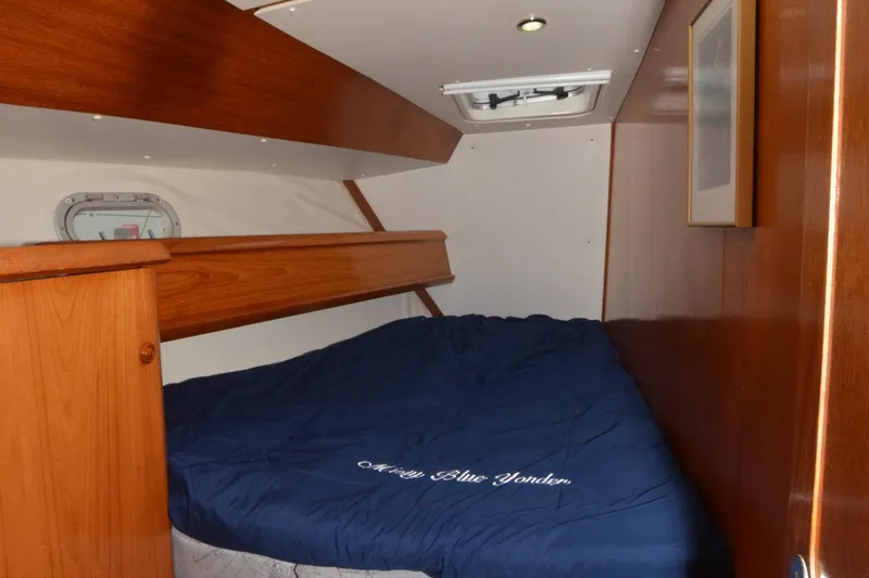 Misty Blue Yonder Yacht Photos Pics Cozy cabin interior of 1995 Jeanneau Sun Odyssey 45.1 sailboat with blue bedding.
