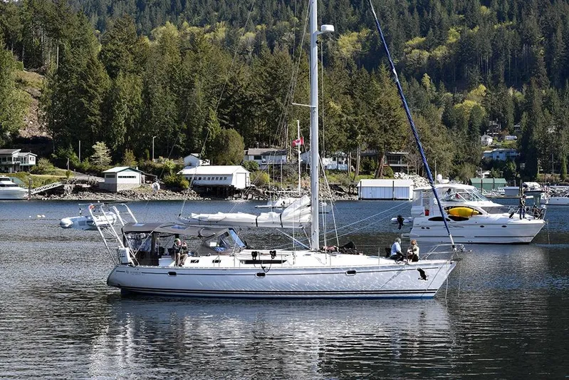 Misty Blue Yonder Yacht Photos Pics Jeanneau Sun Odyssey 45.1 sailboat from 1995 on a serene lake with forested backdrop.