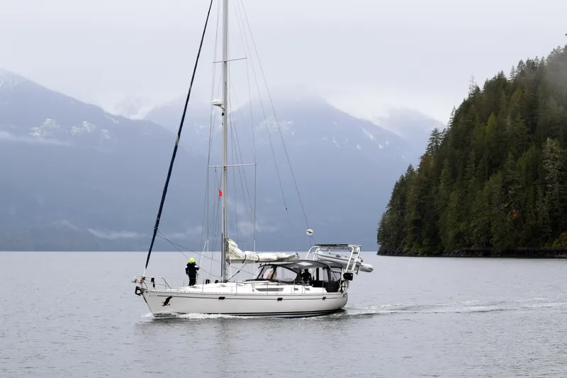 Misty Blue Yonder Yacht Photos Pics Sailboat Jeanneau Sun Odyssey 45.1, 1995, cruising near forested mountains on a misty day.