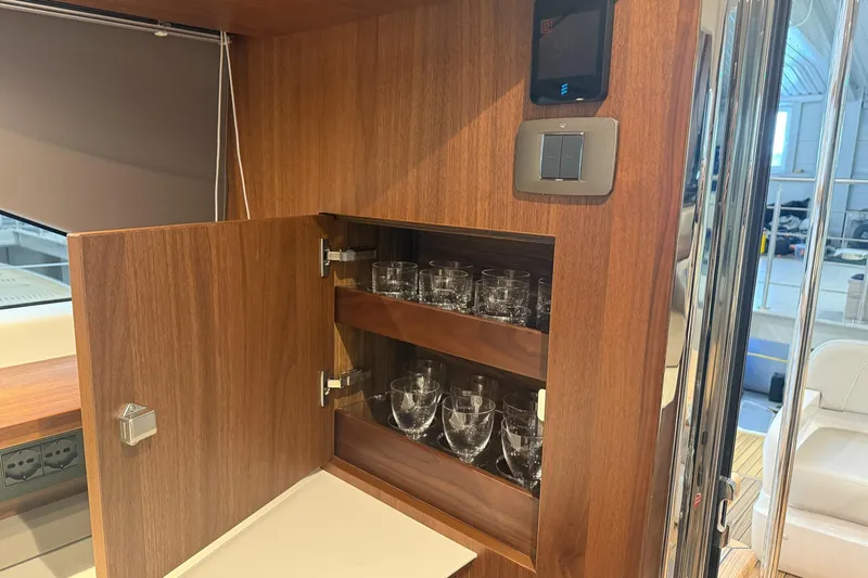 F45095 Yacht Photos Pics Luxurious wooden cabinet with glassware inside a 2023 Princess F45 yacht interior.