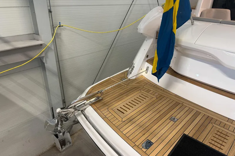 F45095 Yacht Photos Pics 2023 Princess F45 yacht with teak deck and flag, docked indoors.